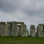 a stonehenge in a grassy field under a cloudy sky