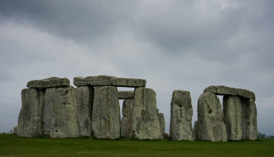 a stonehenge in a grassy field under a cloudy sky