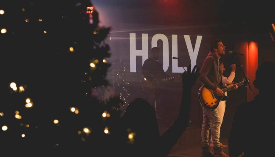 man performing on stage performing christmas music